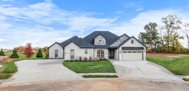 french country inspired facade featuring a garage and a front yard