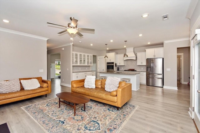 living room featuring ornamental molding, sink, ceiling fan, and light hardwood / wood-style floors