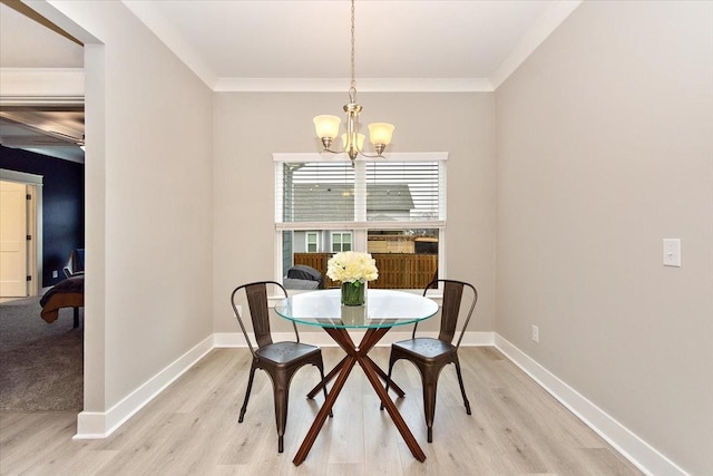 dining area featuring crown molding, light wood-type flooring, and an inviting chandelier