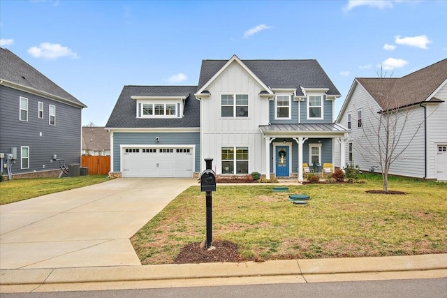 view of front of home featuring cooling unit, a garage, a front lawn, and a porch