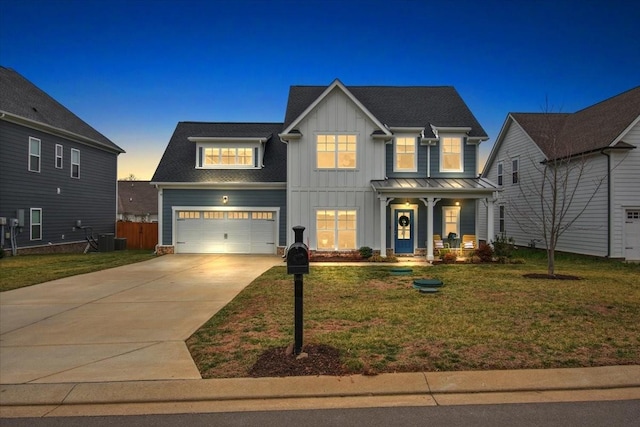 view of front of property featuring a garage, a porch, cooling unit, and a lawn