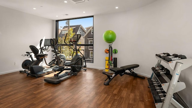 workout room with dark hardwood / wood-style flooring and floor to ceiling windows