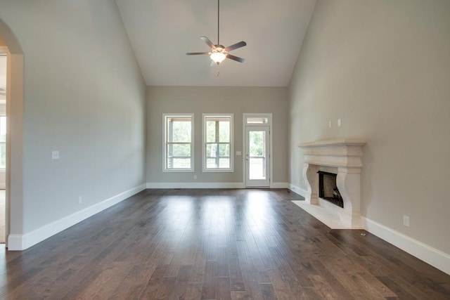 unfurnished living room featuring ceiling fan, high vaulted ceiling, a fireplace, and dark hardwood / wood-style flooring