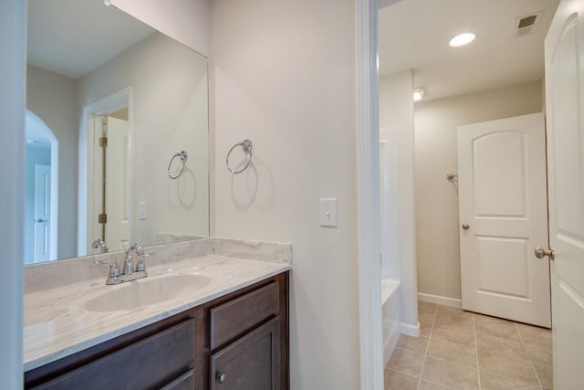 bathroom featuring tile patterned flooring, vanity, and a bathing tub