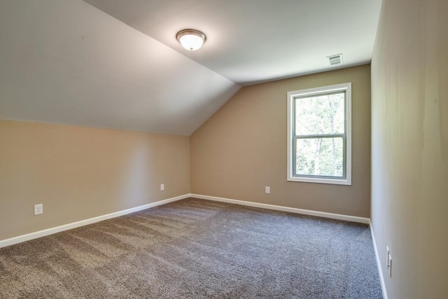 bonus room with vaulted ceiling and carpet floors