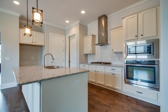 kitchen featuring sink, a kitchen island with sink, light stone counters, stainless steel appliances, and wall chimney range hood