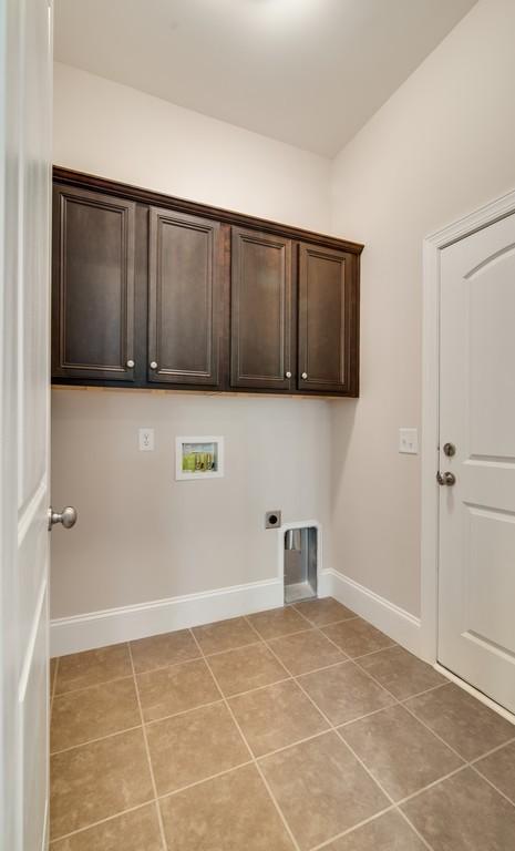 laundry room featuring cabinets, hookup for an electric dryer, hookup for a washing machine, and light tile patterned floors