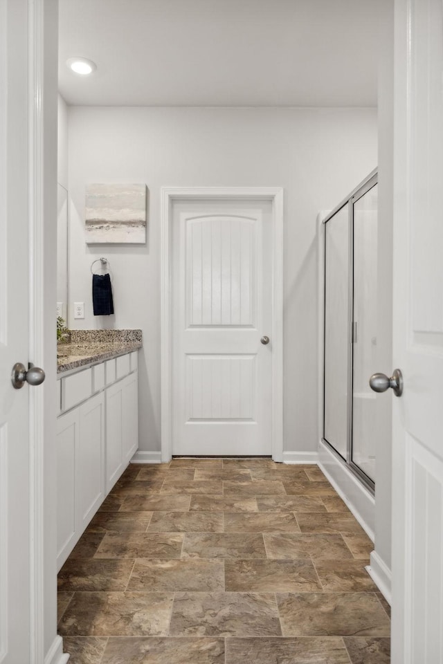 bathroom with vanity and a shower with shower door