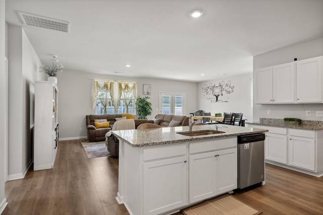 kitchen with sink, dishwasher, a kitchen island with sink, light stone countertops, and white cabinets