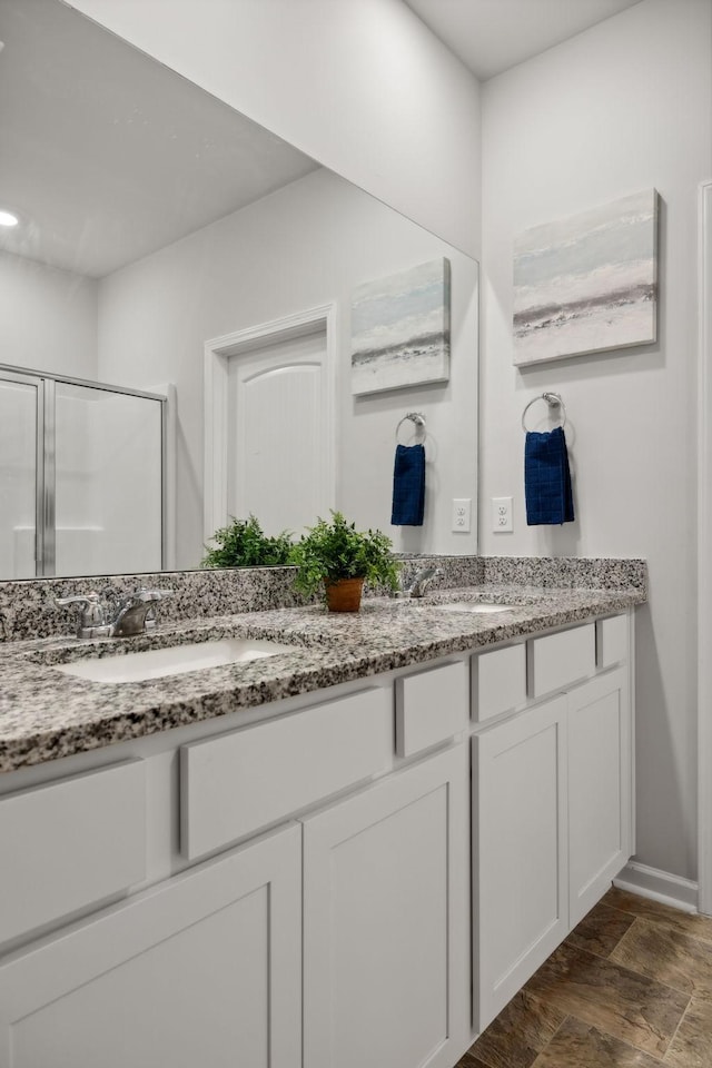 bathroom featuring vanity and a shower with door