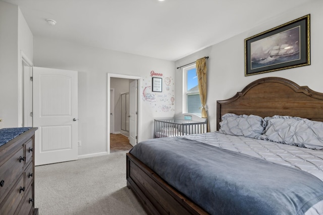 bedroom featuring ensuite bathroom and light colored carpet