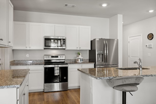 kitchen featuring white cabinetry, sink, a kitchen island with sink, and appliances with stainless steel finishes