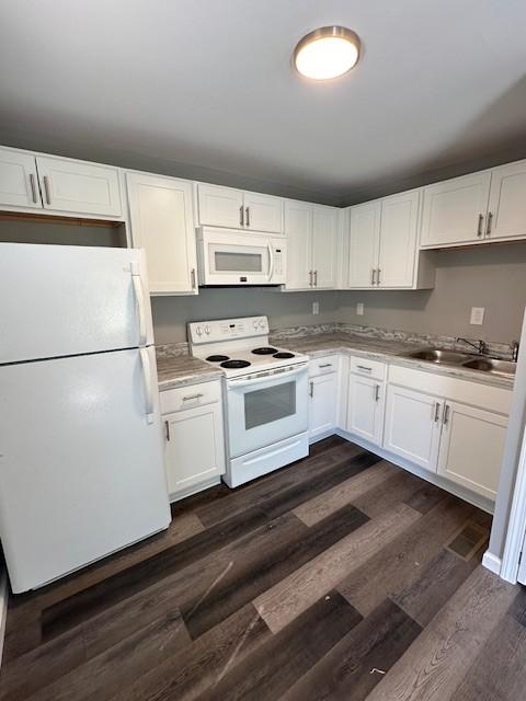 kitchen with sink, dark wood-type flooring, white cabinets, and white appliances