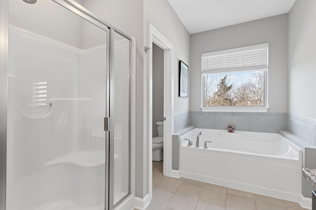 bathroom featuring independent shower and bath, tile patterned flooring, and toilet