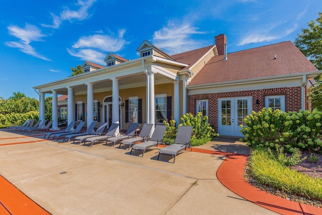 rear view of house with french doors, a porch, and a patio