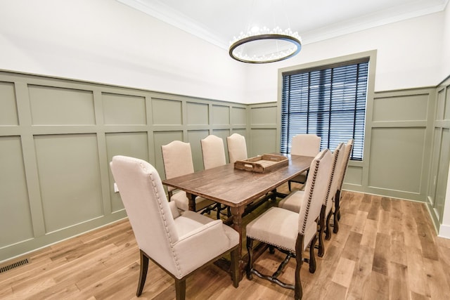 dining area featuring ornamental molding and light hardwood / wood-style floors