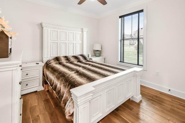 bedroom featuring ornamental molding, ceiling fan, and dark hardwood / wood-style flooring