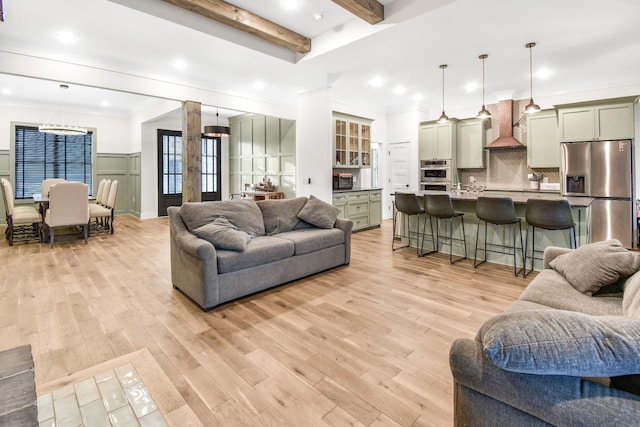 living room with ornamental molding, beam ceiling, and light hardwood / wood-style flooring