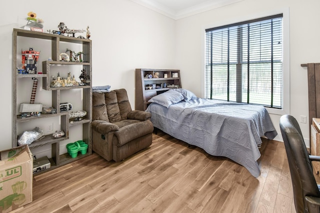 bedroom with crown molding and hardwood / wood-style floors