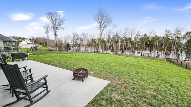 view of yard featuring a patio, a water view, and an outdoor fire pit