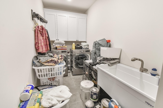 clothes washing area with cabinets, sink, light tile patterned floors, and independent washer and dryer