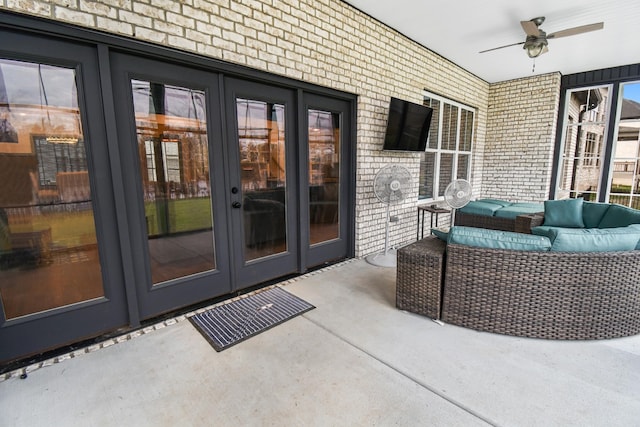 view of exterior entry featuring an outdoor living space, a patio area, ceiling fan, and french doors