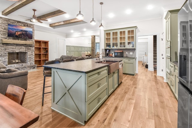 kitchen featuring sink, decorative backsplash, a kitchen breakfast bar, and green cabinetry