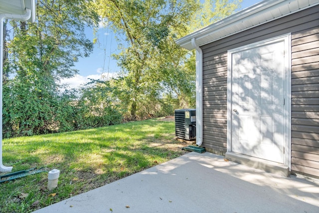 view of yard with central AC and a patio