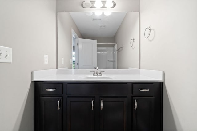 bathroom featuring walk in shower and vanity