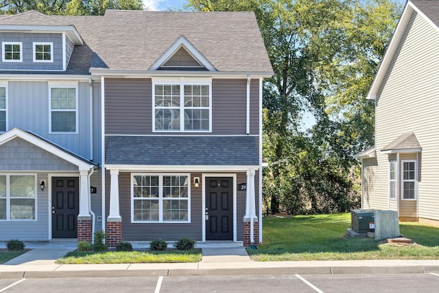 view of front of house with central air condition unit and a front lawn