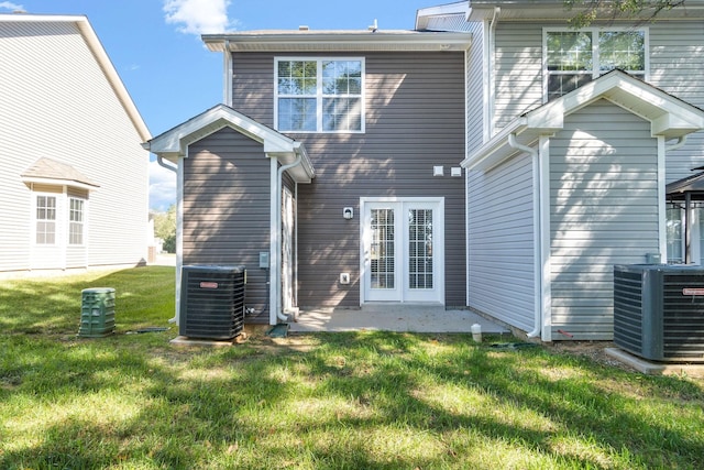 back of property with a lawn and central air condition unit