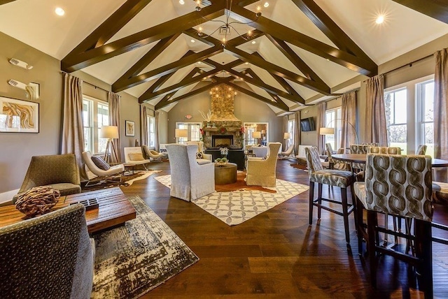 living room featuring a chandelier, wood finished floors, beamed ceiling, a fireplace, and high vaulted ceiling