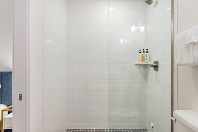 bathroom with tiled shower and toilet