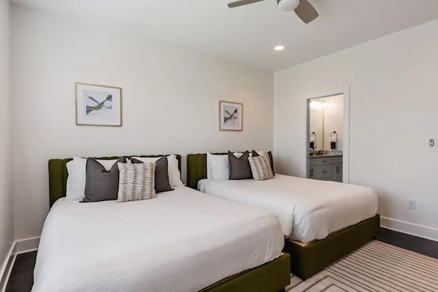 bedroom with ceiling fan, connected bathroom, and dark hardwood / wood-style flooring