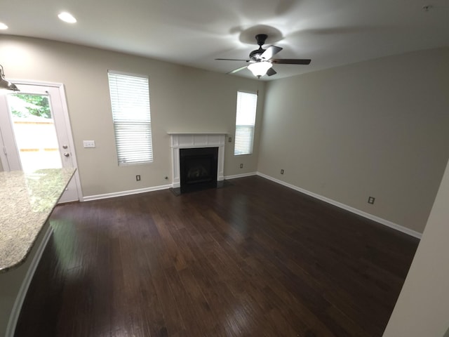 unfurnished living room with ceiling fan and dark hardwood / wood-style floors