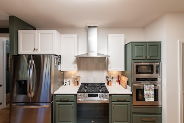 kitchen with tasteful backsplash, wall chimney range hood, white cabinetry, and stainless steel appliances