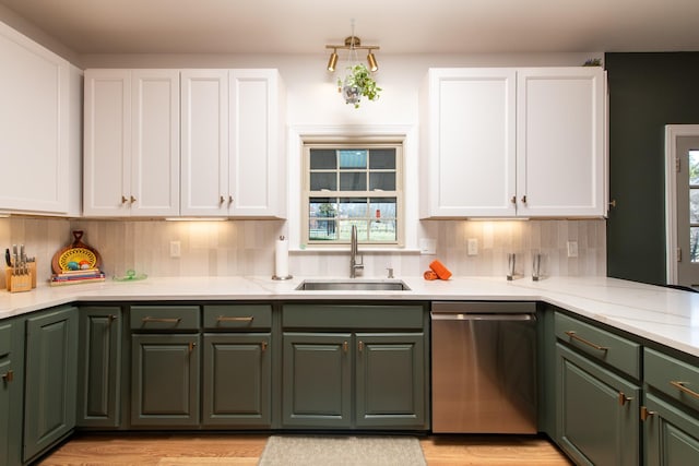 kitchen featuring sink, white cabinetry, light hardwood / wood-style flooring, dishwasher, and backsplash