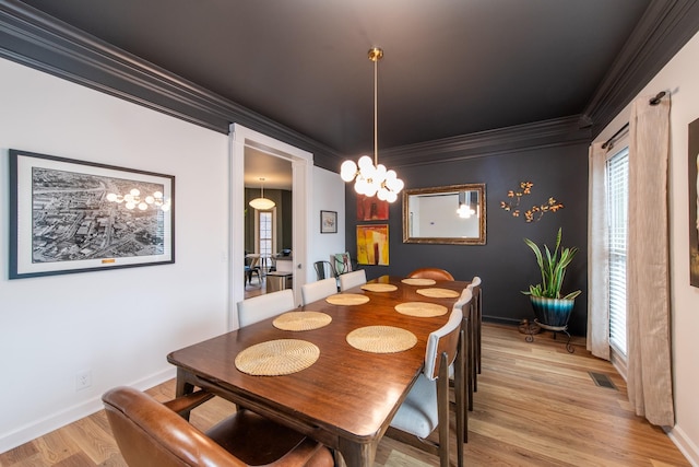 dining area with crown molding, light hardwood / wood-style flooring, and a notable chandelier