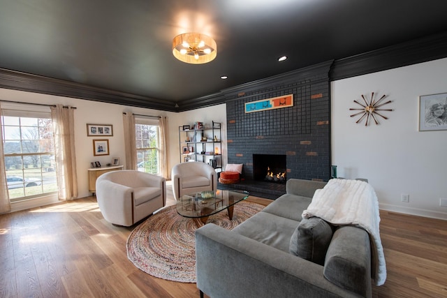 living room featuring a brick fireplace, ornamental molding, and hardwood / wood-style floors