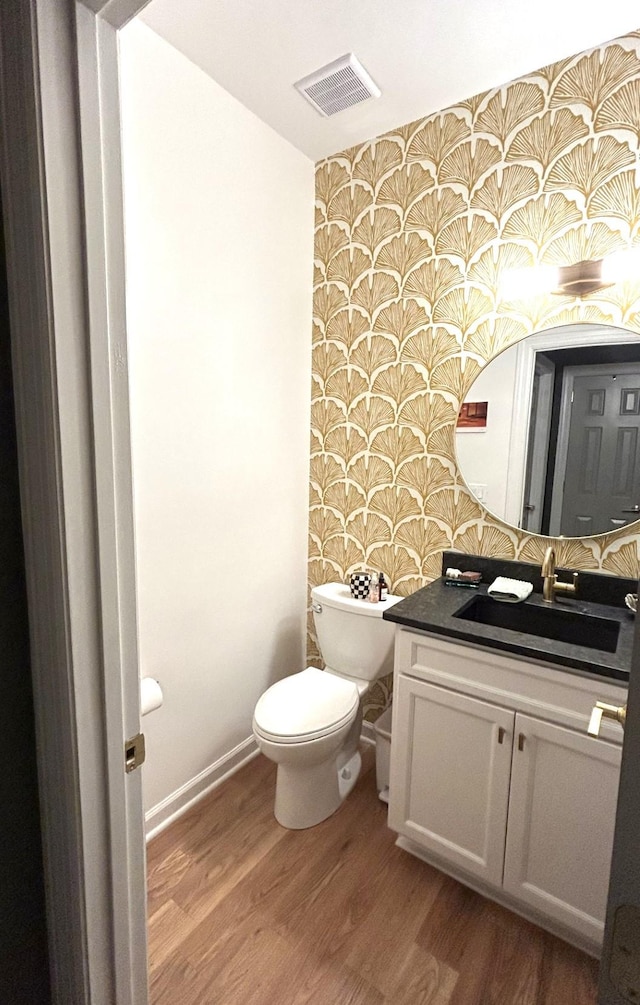 bathroom featuring vanity, hardwood / wood-style floors, and toilet