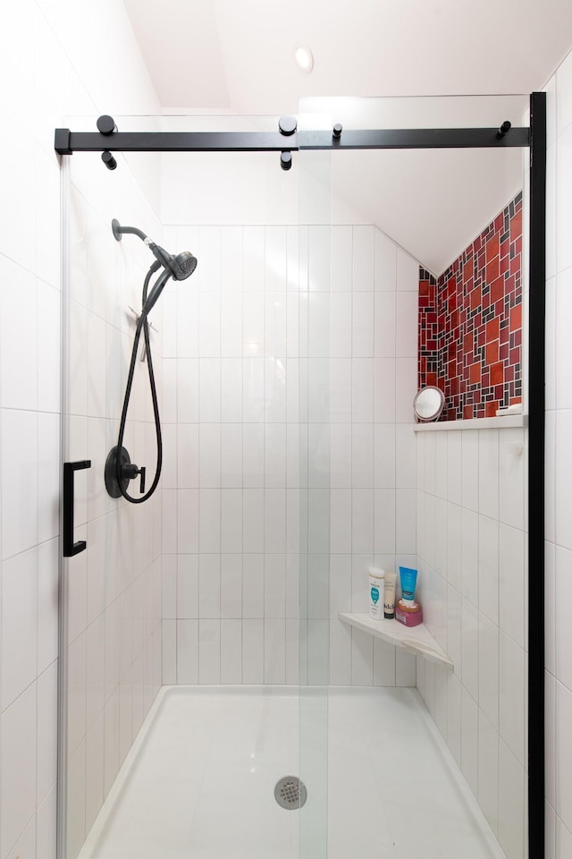 bathroom with a shower with shower door and vaulted ceiling