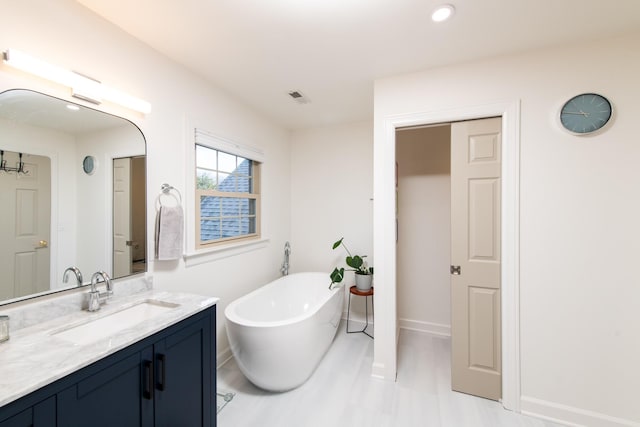 bathroom with vanity and a washtub