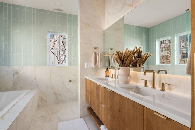 bathroom featuring vanity, tile walls, and tiled tub