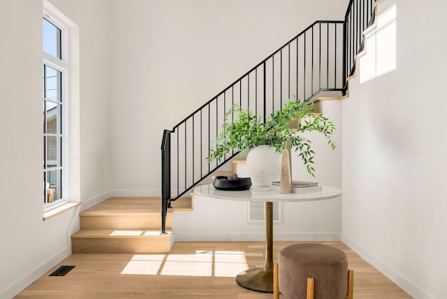 staircase featuring wood finished floors and baseboards