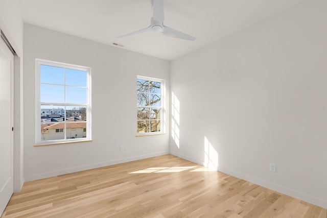 empty room with ceiling fan and light hardwood / wood-style flooring