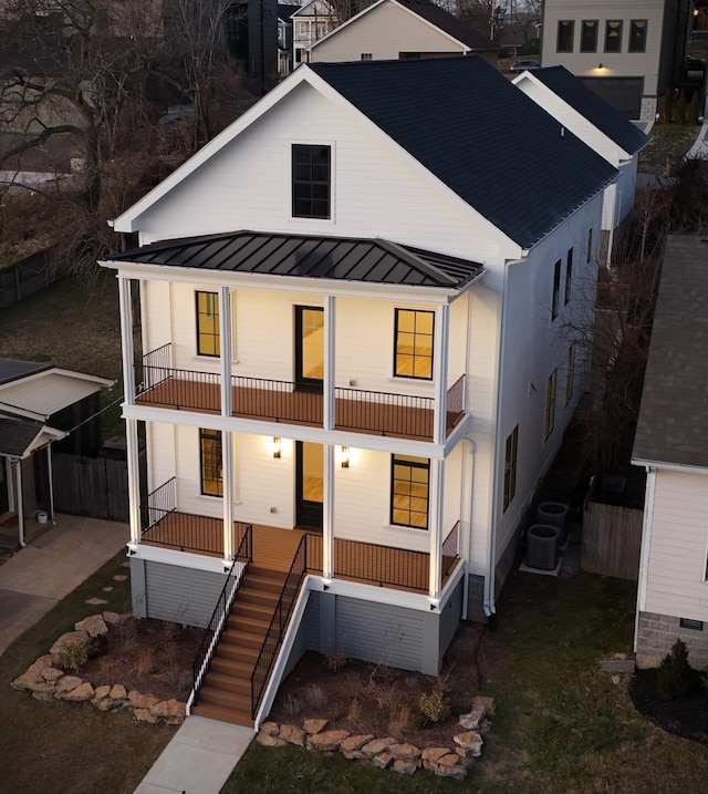 view of front of property featuring central AC, a balcony, and a porch