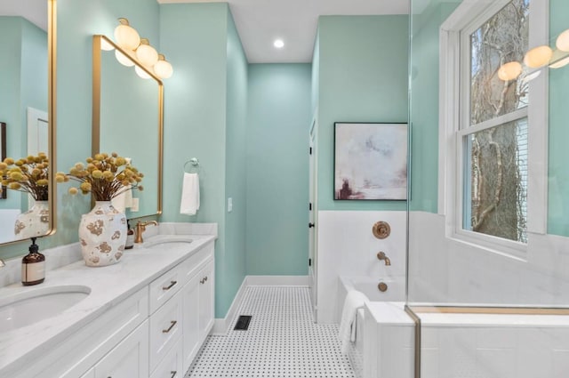 bathroom with vanity and tiled tub