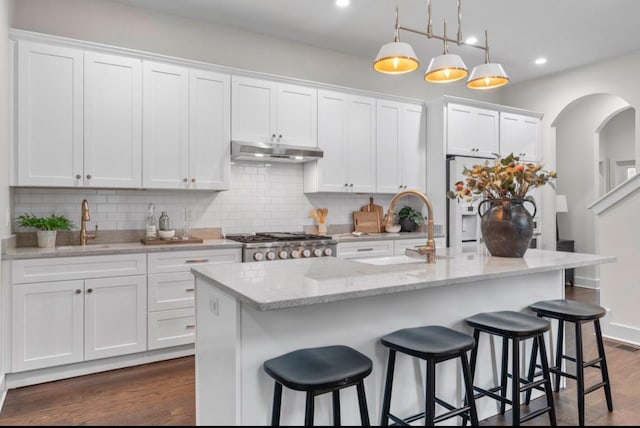 kitchen featuring a center island with sink and white cabinets