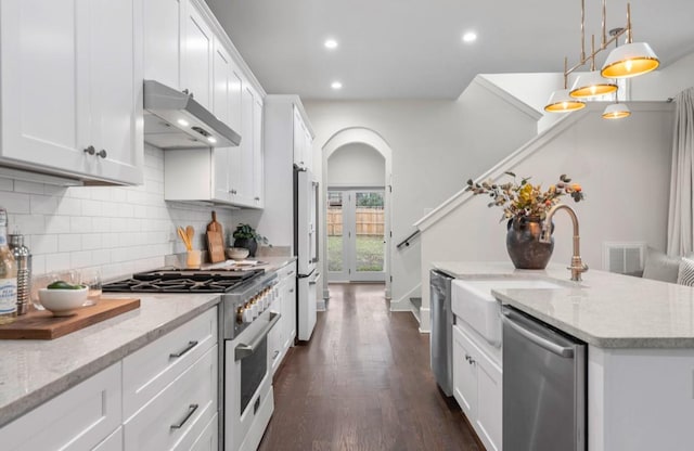 kitchen featuring white cabinetry, high quality appliances, decorative light fixtures, and light stone countertops