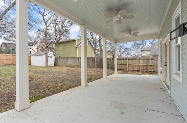 view of patio featuring ceiling fan and a shed